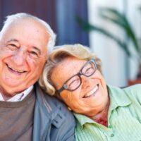 Pareja de personas mayores sonriendo al aire libre
