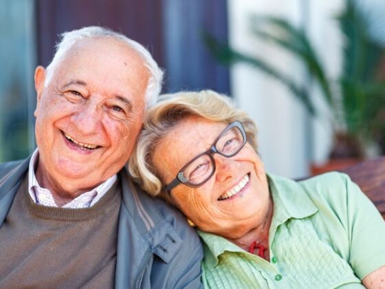 Pareja de personas mayores sonriendo al aire libre