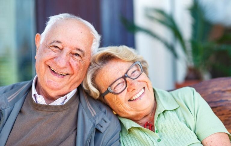 Pareja de personas mayores sonriendo al aire libre