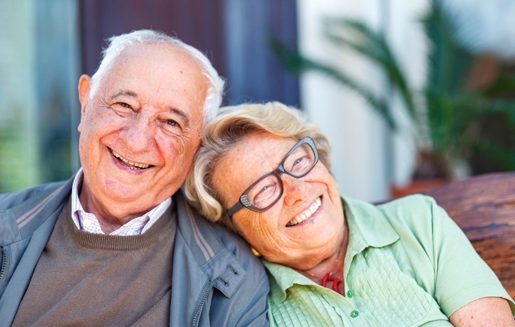 Pareja de personas mayores sonriendo al aire libre